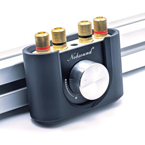 Op de afbeelding: Een zwarte audioversterker met goudkleurige luidsprekeraansluitingen en een zilveren volumeknop. De versterker heeft de merknaam "NobSound". De aansluitingen hebben rode en zwarte accenten.