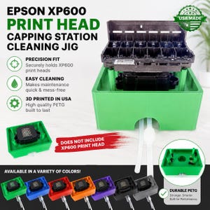 Op de afbeelding: Een groene 3D-geprinte Epson XP600 printkop reinigingsstation gemaakt van PETG. Het apparaat heeft een basis met twee witte slangen en een zwart printkoponderdeel. De tekst bevat EPSON XP600 PRINT HEAD CAPPING STATION CLEANING JIG.