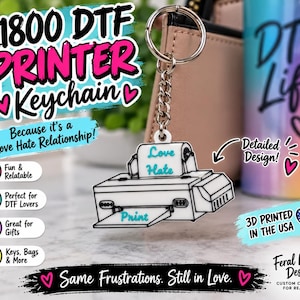 May include: A white keychain shaped like an L1800 DTF printer with black outlines. The printer features the text Love Hate on the paper feed and Print on the tray. It is attached to a silver metal split ring by a short silver chain.