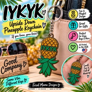 Puede incluir: Un llavero con diseño de piña invertida con cuerpo dorado brillante y hojas verdes. El texto IYKYK está impreso en verde sobre la piña. El llavero incluye una anilla y cadena de metal plateado, mostrado frente a un bolso de color rosa y negro.