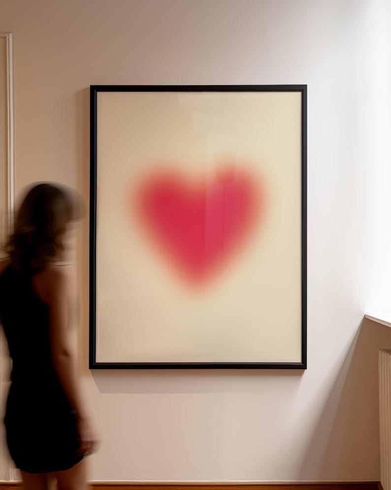 May include: A framed print of a blurry, pink heart shape on a white background.