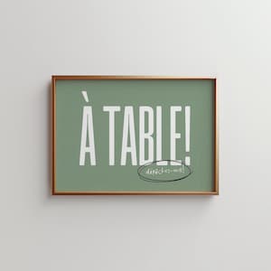 May include: A framed print with a green background and white text that says "À TABLE!" with the words "dépêchez-vous!" written in a circle underneath.