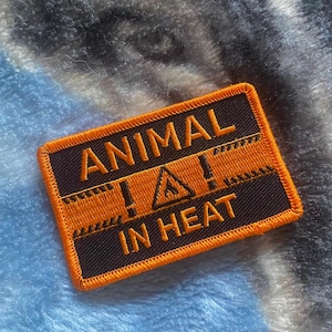May include: Orange and black embroidered patch with the text "ANIMAL! IN HEAT" and a warning sign with a flame inside.