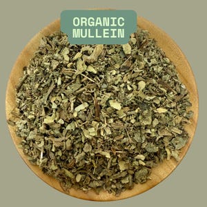 May include: A wooden bowl filled with dried, green organic mullein leaves. The text "ORGANIC MULLEIN" is displayed on a green rectangular label above the bowl. The leaves have a variety of textures and shades of green and brown.