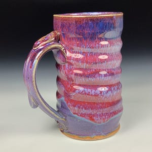 Puede incluir: Un juego de tres tazas de cerámica con un acabado mate moteado. Las tazas son de color crema, gris claro y gris oscuro. Cada taza tiene un diseño simple y minimalista y un asa redondeada.