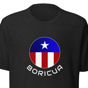 May include: A black t-shirt with a white circle containing a red, white, and blue Puerto Rican flag design. The text "BORICUA" is printed in white below the circle.