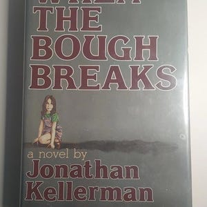 Puede incluir: Portada del libro "When the Bough Breaks" de Jonathan Kellerman. La portada presenta un fondo gris con el título en letras grandes de color granate. Se muestra una niña con una camisa verde y un peto, y el nombre del autor en la parte inferior.