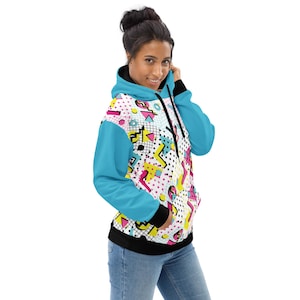 May include: A hooded sweatshirt with a vibrant 80s-inspired design. The hoodie features a white base with a colorful pattern of geometric shapes, polka dots, and musical notes. It has bright blue sleeves, a black hood lining, and a black hem.