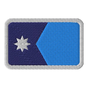 May include: Embroidered patch featuring a design with a dark blue background, a light blue section, and a white star. The patch has a rectangular shape with a gray border.