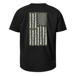 Könnte beinhalten: Schwarzes T-Shirt mit einem grafischen Motiv der amerikanischen Flagge. Die Streifen werden durch gerollte Zigaretten gebildet, und die Sterne werden durch Cannabisblätter ersetzt. Das Design ist in Weiß und Grün gehalten.