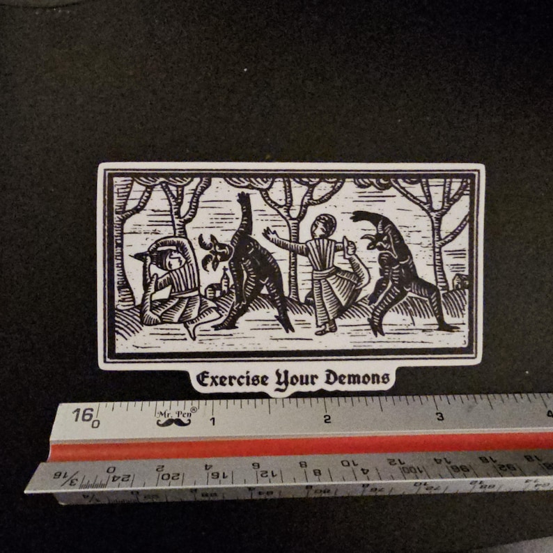 May include: Black and white sticker with a woodcut-style illustration of figures interacting with demonic creatures. The text "Exercise Your Demons" is at the bottom. The sticker is approximately 4 inches long.