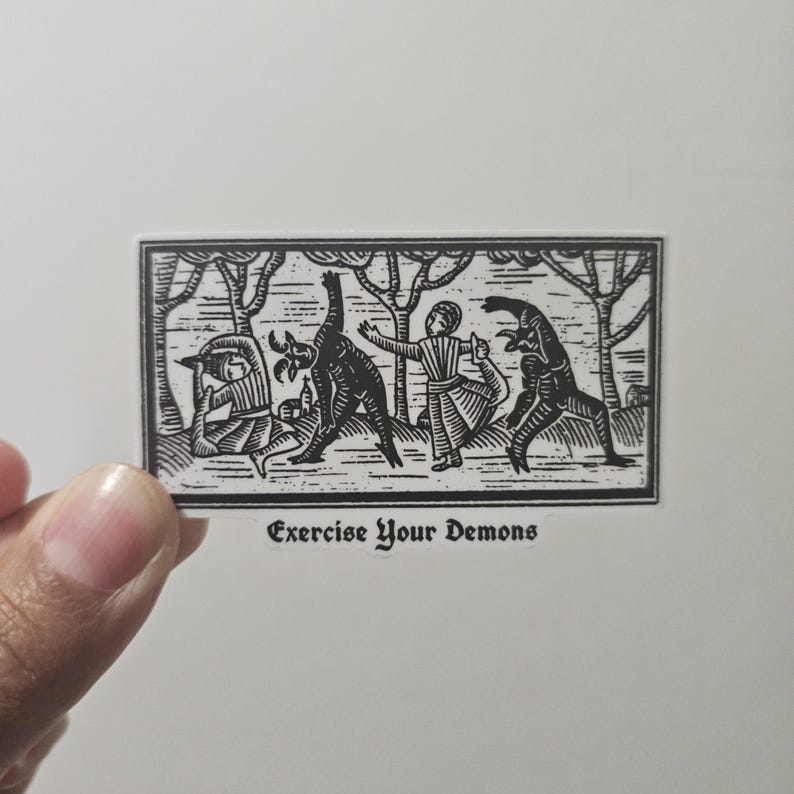 May include: A black and white sticker with a woodcut-style illustration. The image depicts figures interacting with demonic creatures in a forest setting. The text "Exercise Your Demons" is at the bottom.