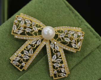 Broche de lazo dorado con perla de Akoya y cristales: elegante broche de lazo