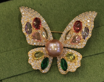 Broche de mariposa dorado hecho a mano: detalles de perlas Edison y cristales.
