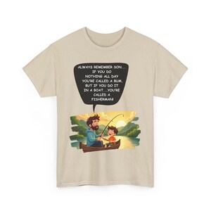 May include: Beige t-shirt featuring a cartoon illustration of a father and son fishing in a boat. The image includes the text: "ALWAYS REMEMBER SON... IF YOU DO NOTHING ALL DAY YOU'RE CALLED A BUM, BUT IF YOU DO IT IN A BOAT...YOU'RE CALLED A FISHERMAN!"