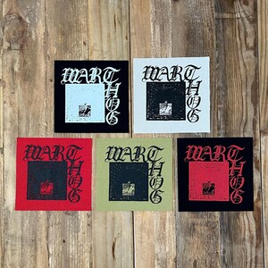 May include: Five square fabric patches featuring the text WART HOG in a gothic font. The patches come in various color combinations: black with light blue, white with black, red with black, olive green with black, and black with red accents.