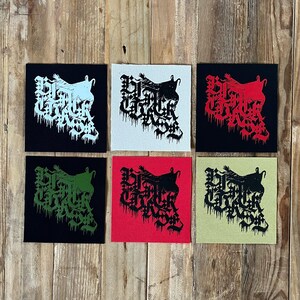 May include: Six square fabric patches arranged in two rows of three. Each patch features a black graphic design with stylized, dripping gothic lettering that reads Black Church. The patches come in various color combinations including black, white, red, and olive.