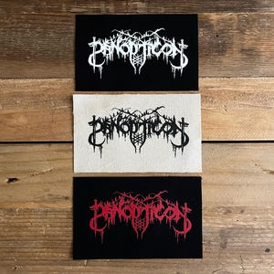 May include: Three rectangular patches with the word "PANOPTICON" in a stylized font. The top and bottom patches are black with white and red text, respectively. The middle patch is off-white with black text.