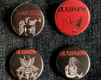 May include: Four circular badges with the word "BLASPHEMY" in a gothic font. The badges feature black and white illustrations of figures and symbols, with one badge in red. The badges are displayed on a denim background.