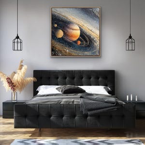 May include: A framed abstract painting of a planet with rings, in shades of orange, brown, and blue. The artwork is displayed above a black tufted bed with a gray blanket and pillows. The room has a modern design with black nightstands and pendant lights.