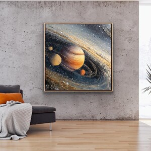May include: A framed abstract painting of a planet with swirling rings and smaller celestial bodies. The artwork features shades of orange, blue, and gold, creating a cosmic theme. The painting hangs on a textured gray wall.
