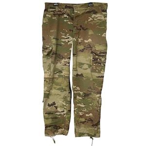 May include: Camouflage cargo pants in shades of green, brown, and tan. The pants feature multiple pockets, a button and zipper closure, and drawstrings at the ankles. The fabric has a military-style pattern.