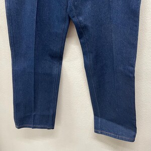 Op de afbeelding: Donkerblauwe spijkerbroek met een rechte pijp. De broek heeft een klassiek ontwerp met vijf zakken en een knoop- en ritssluiting. De denimstof lijkt een gemiddeld gewicht te hebben, geschikt voor het hele jaar door.