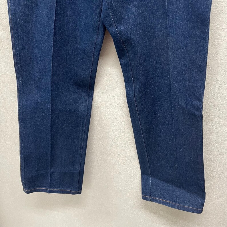 Op de afbeelding: Donkerblauwe spijkerbroek met een rechte pijp. De broek heeft een klassiek ontwerp met vijf zakken en een knoop- en ritssluiting. De denimstof lijkt een gemiddeld gewicht te hebben, geschikt voor het hele jaar door.