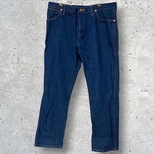 May include: Dark blue denim jeans with a classic five-pocket design. The jeans have a button and zipper closure, and copper-colored rivets. The straight-leg style is visible in this full-length shot.