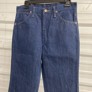 Puede incluir: Vaqueros de mezclilla azul oscuro con un dise&ntilde;o cl&aacute;sico de cinco bolsillos. Los vaqueros tienen cierre de bot&oacute;n y cremallera, trabillas para el cintur&oacute;n y remaches de color cobre. La tela parece ser una mezclilla de peso medio.
