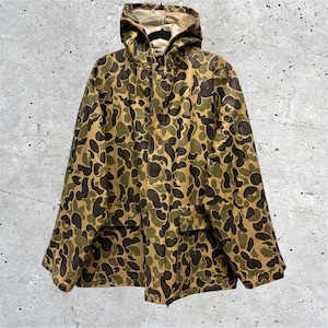 May include: A hooded jacket featuring a camouflage pattern in shades of brown, olive green, and tan. The jacket includes a front button closure, long sleeves, and two front pockets with buttoned flaps. The interior lining is a solid light beige color.