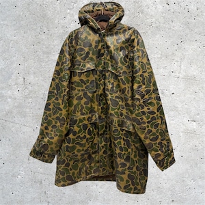 May include: A long-sleeved hooded jacket featuring a camouflage pattern in shades of olive green, dark brown, and tan. The jacket includes a front button closure, two chest pockets with flaps, and two lower pockets with flaps, all with a brown interior lining.