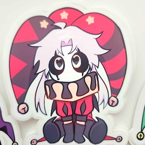 May include: A sticker featuring a cartoon jester character with a white face, black eyes, and a red and black jester hat. The jester wears a red and black outfit with a black collar and is sitting down. The sticker has a white border.
