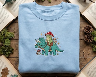 Sudadera de dinosaurio con rana montada, cuello redondo con triceratops bordado, camiseta de dinosaurio cottagecore, top de animal de fantasía, bonito regalo de reptil, prehistórico