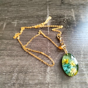 Resin pendant with dried flowers.