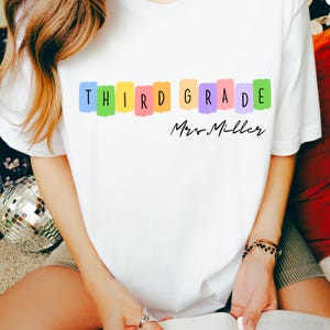 3年生の先生用シャツ、先生の名前が入ったカスタムTシャツ、新学期用のスウェットシャツ、3年生用のパーカー、カラフルな先生へのギフトアイデア、カスタムTシャツ