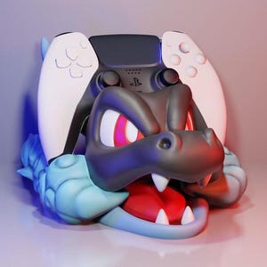 May include: A black and white PlayStation 5 controller rests inside a stylized dragon-like figure. The dragon has a gray head, red eyes, and a red tongue. The figure is blue and white.