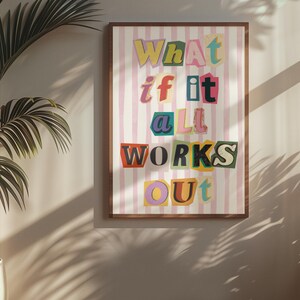 May include: A pink and white striped poster with the text "What if it all works out" in colorful, cut-out letters.