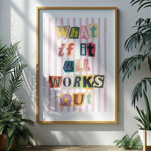 May include: A framed print with a pink and white striped background and the text "What if it all works out" in colorful, cut-out letters.