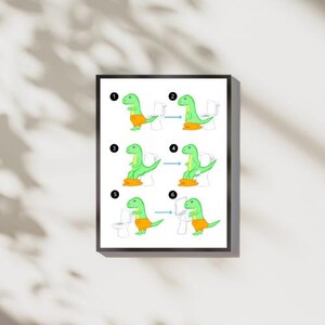 May include: A framed print featuring a green cartoon dinosaur in orange shorts, demonstrating toilet use in six numbered steps. The dinosaur is shown sitting on a toilet, with arrows indicating the sequence. The background is white.