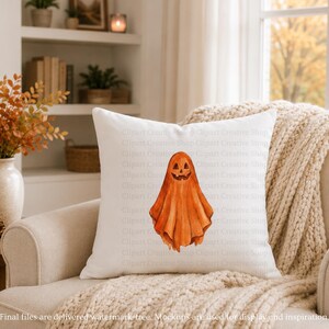 Puede incluir: Un coj&iacute;n decorativo cuadrado de color blanco con una ilustraci&oacute;n central en acuarela de un fantasma naranja con una cara de calabaza tallada. El fantasma tiene un aspecto drapeado y fluido con texturas de pinceladas en naranja calabaza.