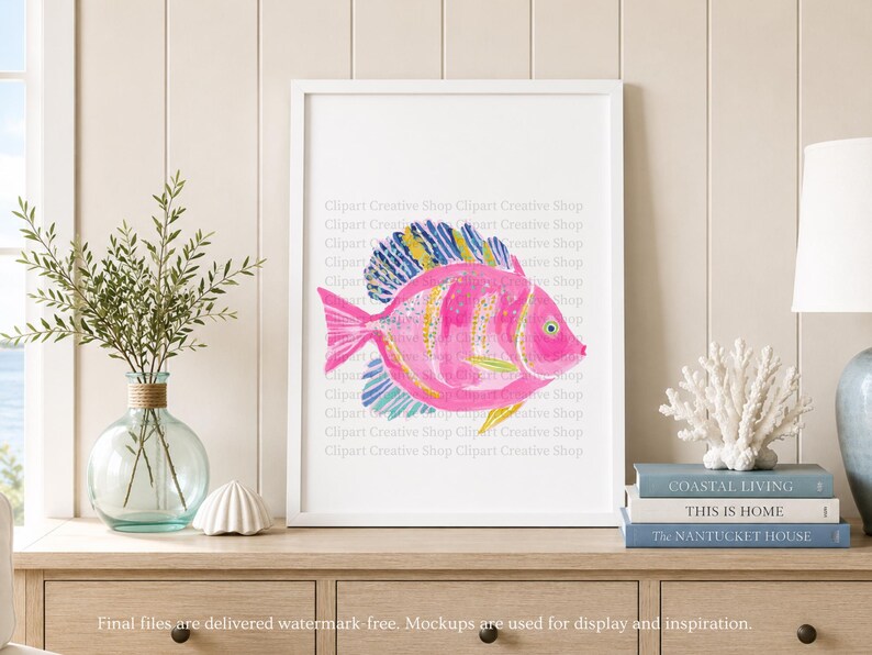 K&ouml;nnte beinhalten: Ein gerahmter Kunstdruck mit einer Aquarell-Illustration eines leuchtend rosa Fisches mit gelb und blau gestreiften Flossen. Der Fisch hat ein deutliches Auge und Schuppen und ist in einem wei&szlig;en Rahmen vor einer hellen Wand platziert.