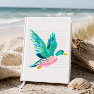 Op de afbeelding: Een wit notitieboek met een aquarelillustratie van een vliegende eend met levendige blauwgroene vleugels, een roze lichaam met gouden accenten en een gele snavel. De kaft toont een herhalend watermerk-tekstpatroon over het centrale grafische deel.