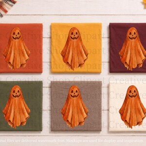 Puede incluir: Seis camisetas dobladas en varios colores, incluyendo naranja, amarillo, granate, verde oliva, gris y crema. Cada camiseta presenta un gr&aacute;fico central estilo acuarela de un fantasma con una cara de calabaza tallada en tonos naranja.