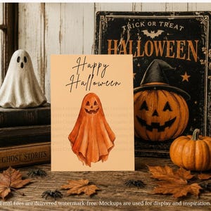Puede incluir: Una tarjeta de felicitaci&oacute;n rectangular con fondo naranja claro que presenta el texto Happy Halloween en letra cursiva negra y una ilustraci&oacute;n en acuarela de un fantasma naranja con cara de calabaza tallada en el centro.