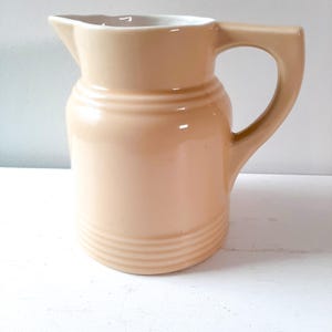 Antique cream-colored Art Deco style ceramic water pitcher, earthenware pitcher, wooden spoon holder