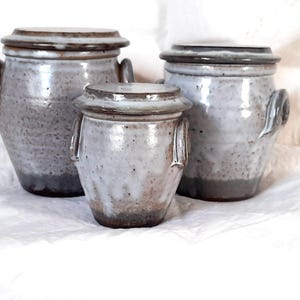 May include: A handmade, wooden cutting board with a natural wood grain. The board features a juice groove and a handle. Dimensions are approximately 16 inches long, 10 inches wide, and 0.75 inches thick.