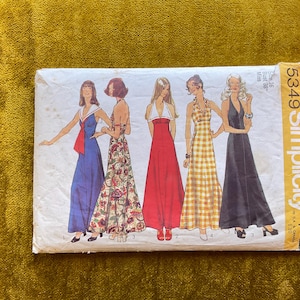 May include: A Simplicity 5349 sewing pattern envelope featuring illustrations of five different floor-length dresses. The text includes the pattern number 5349, the brand name Simplicity, size 16, and bust 38 inches. The dresses vary in color and pattern, including solid blue, floral, solid red, yellow gingham, and solid black.