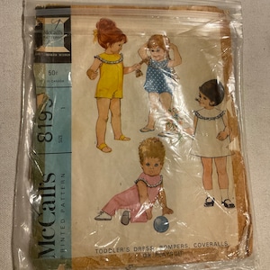 May include: Vintage McCall's sewing pattern for a toddler's dress, rompers, coveralls, or playsuit. The pattern is printed on paper and features illustrations of children wearing the different garments. The pattern number is 819.