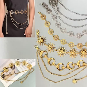 May include: Gold-toned metal body chains with celestial designs. The chains feature sun, moon, and star charms, along with decorative circular and chain elements. One chain is worn around the waist, while others are displayed separately.